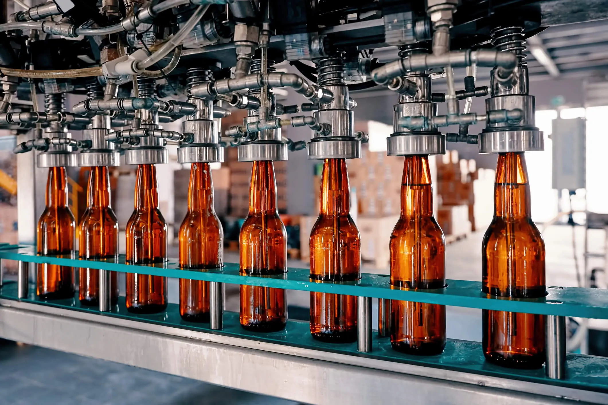 Garrafas de cerveja enchendo a esteira na fábrica de cerveja
