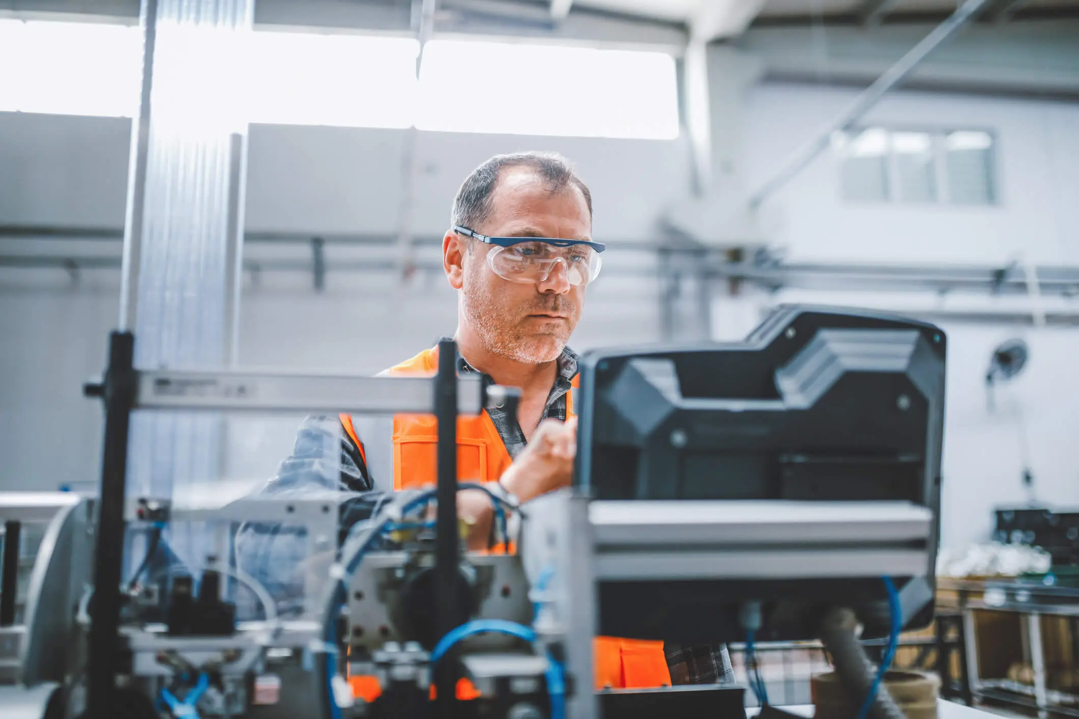 Funcionário profissional de fábrica industrial trabalhando com peças de máquinas colocando, verificando e testando cabos de equipamentos industriais em um grande armazém de fábrica de fabricação de cabos e fios de eletrônicos elétricos