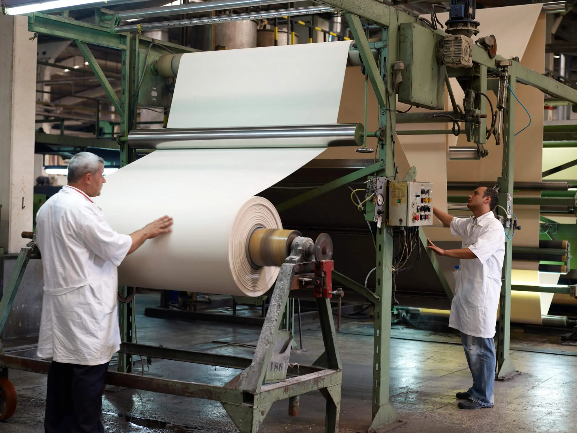 Trabalhadores trabalhando em frente a uma fábrica de tecidos